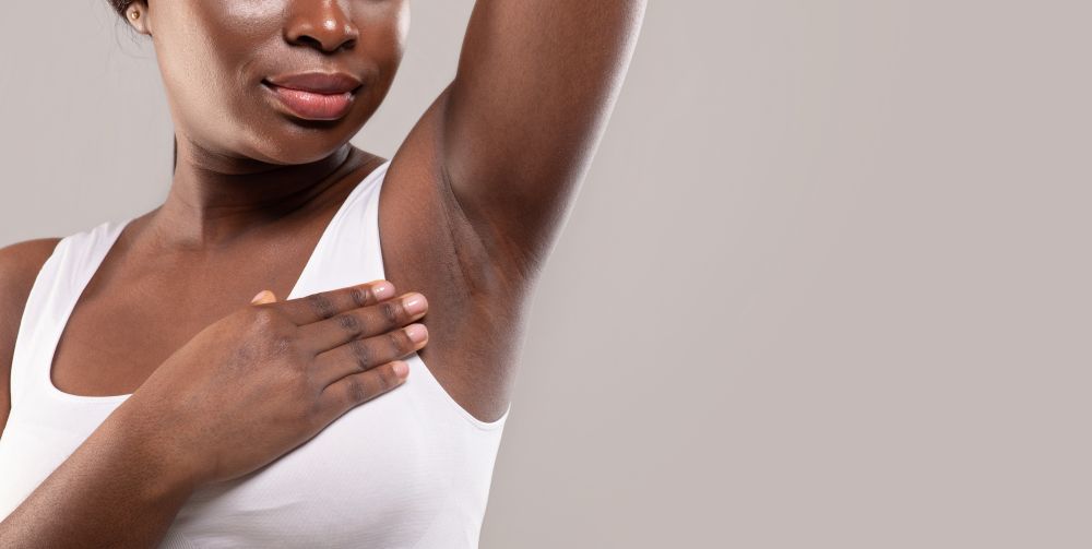 Woman showing smooth even-toned underarms after brightening treatment