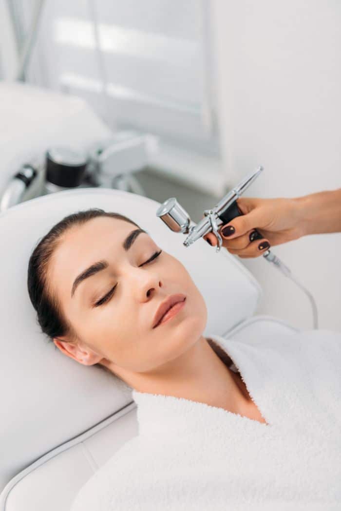 Woman receiving oxygen facial treatment for glowing skin in Manhattan NYC